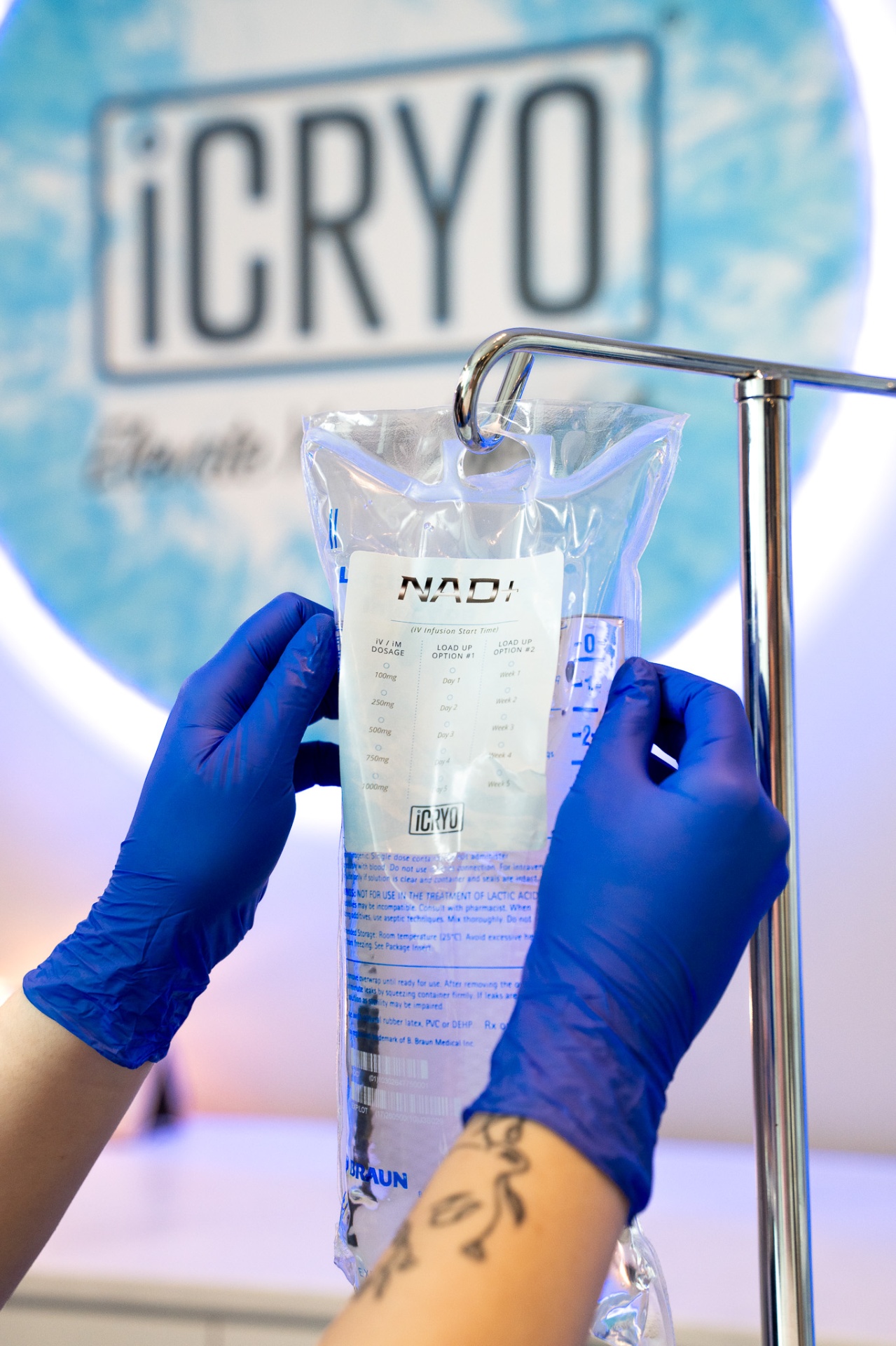 iCRYO Clemson RN holding a NAD+ IV bag in front of the iCRYO logo